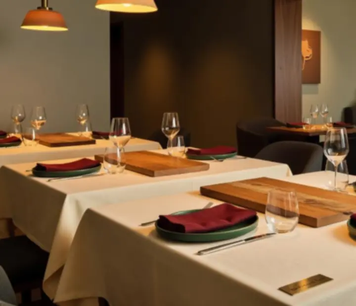 Elegant dining table at The Fortunate Forte with warm lighting and a hint of the Card Lounge beyond.