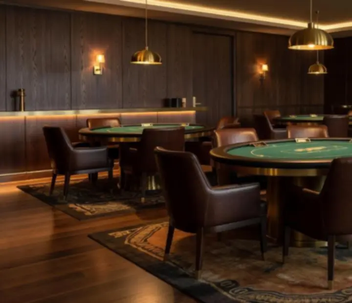 Premium card lounge interior with poker tables, leather chairs and warm amber lighting